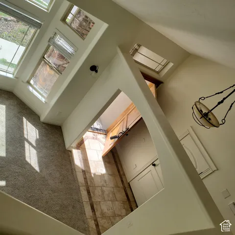 Vaulted ceilings with multiple windows, recessed lighting, and a decorative pendant light fixture