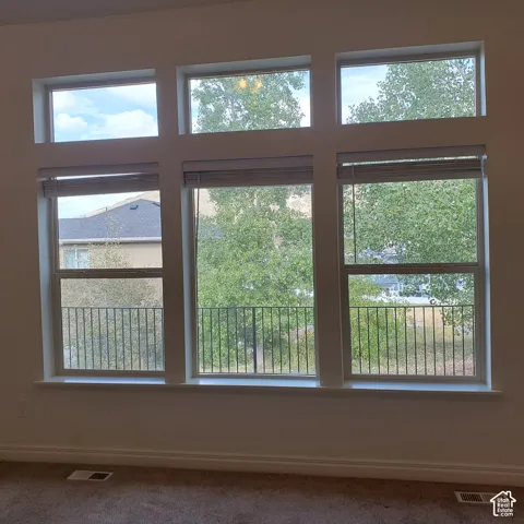 Expansive window array featuring multiple panes, individual window blinds, and a metal balcony railing