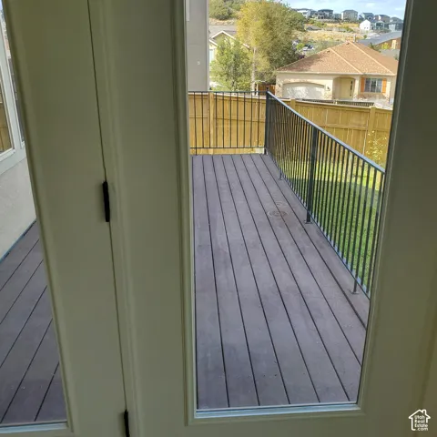 Outdoor deck with composite decking, black metal railing, and a wooden privacy fence