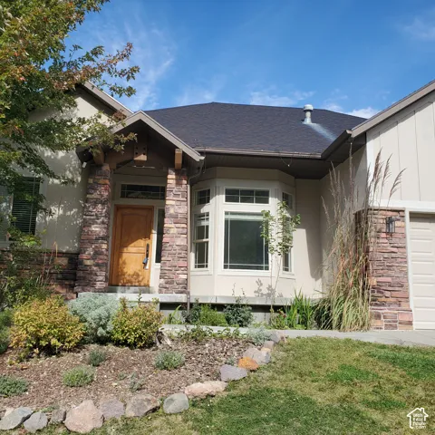 Stucco exterior with stone accents and an asphalt shingle roof