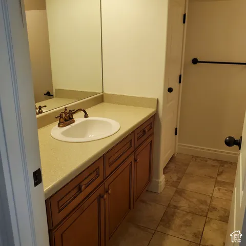 Built-in vanity featuring wood-finish cabinetry, an integrated basin, and a wall-mounted mirror