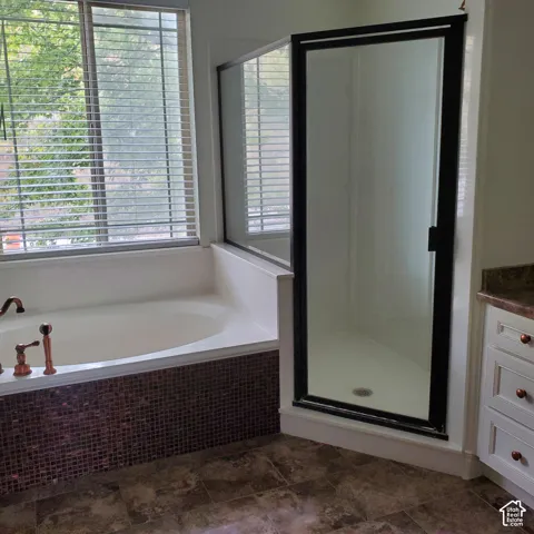 Soaking tub with decorative tile surround and window with blinds