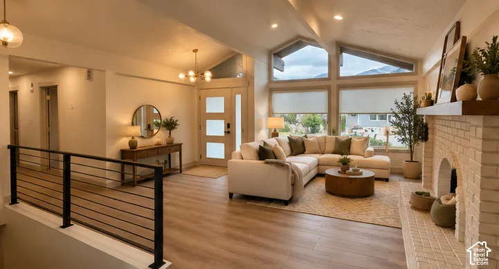 Vaulted ceilings, expansive multi-pane windows, wood-finish flooring, white brick fireplace with a wood mantel, and metal cable railing