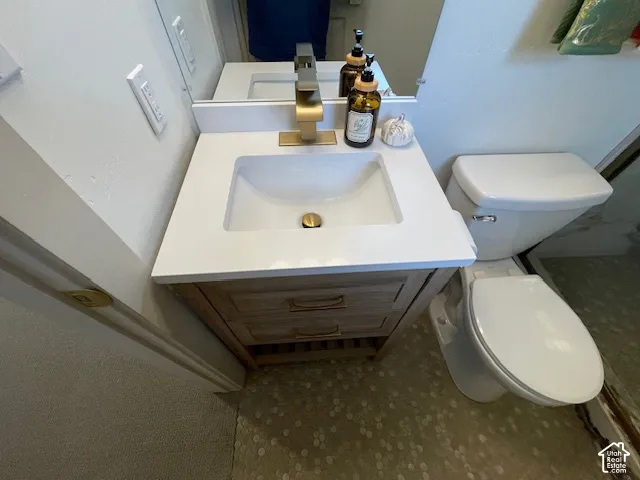 Vanity with integrated sink, brass-finish faucet, and wood-finish cabinetry