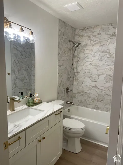 White shaker-style vanity with a single basin, a gold-tone faucet, and a coordinating gold-tone light fixture