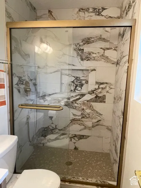 Frameless shower enclosure with a gold-tone trim and handle