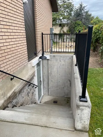 Brick exterior with concrete stairs leading to a below-grade entry