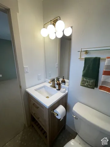 Modern vanity with integrated sink, gold-finish faucet, and coordinating wall-mounted light fixture