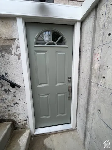Sage green door with an arched transom window and white trim
