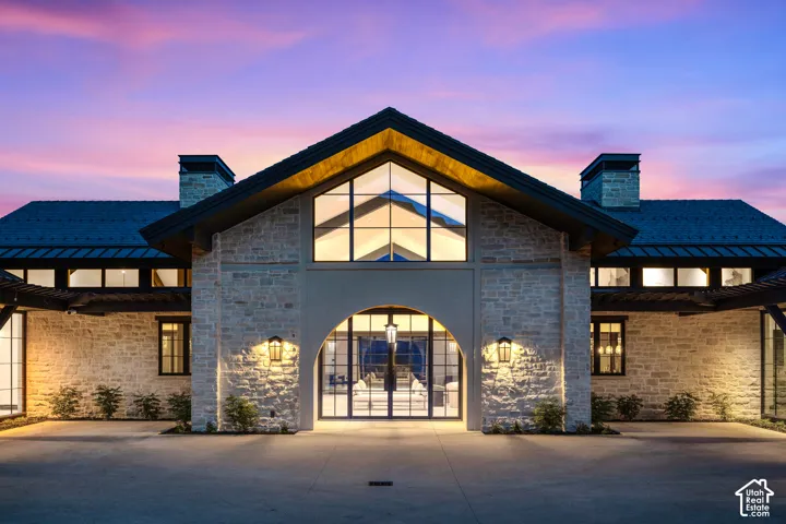 Stone masonry exterior with multiple gables and a dark shingle roof