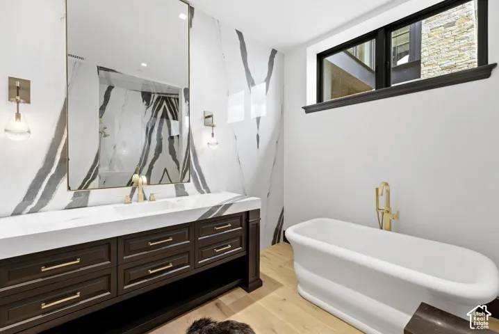 Integrated vanity with dual sinks, gold-finish fixtures, and a large framed mirror