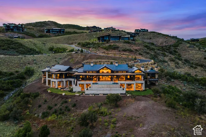 Expansive hillside property featuring a multi-level architectural design, a large terrace, and substantial window walls