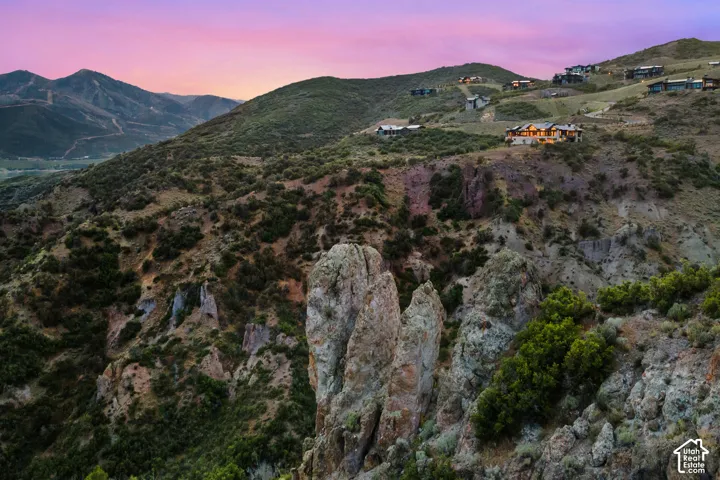 Mountainous terrain with natural rock formations and distant residential structures