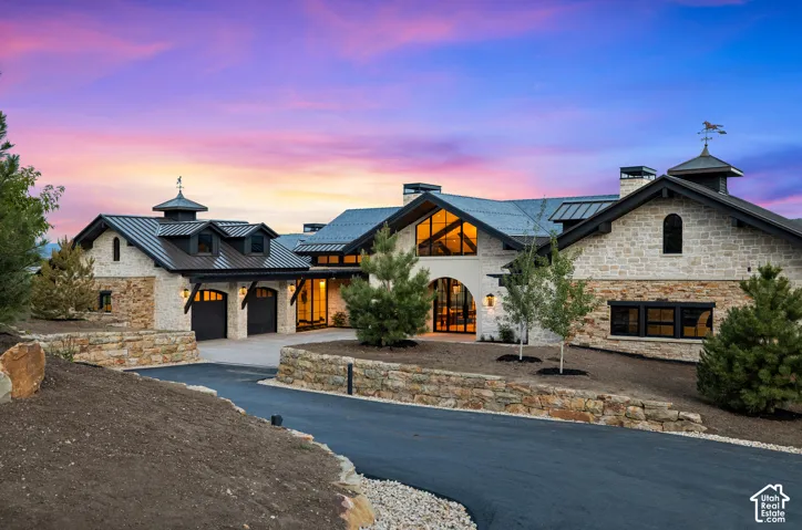 Stone and stucco exterior with multiple gables and a metal roof