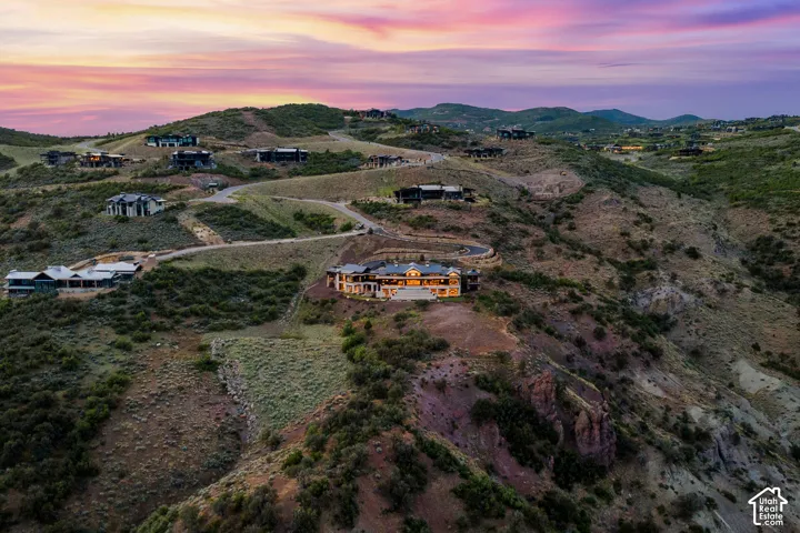 Elevated property featuring a grand exterior, extensive multi-level landscaping, and a winding driveway