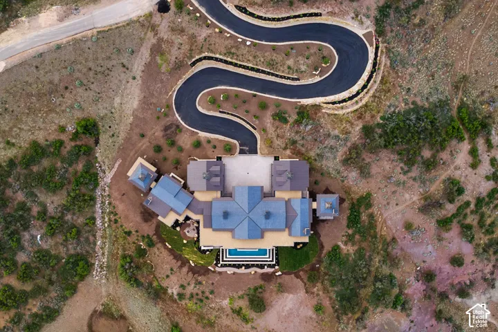 Asphalt driveway with retaining walls, multi-level roofline, multi-story structure, geometric pool