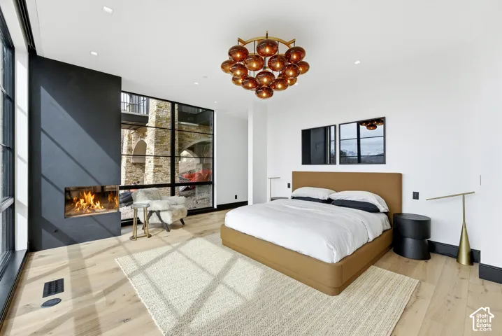 Integrated fireplace, large-pane windows, wood-finish flooring, recessed lighting, and a unique spherical chandelier