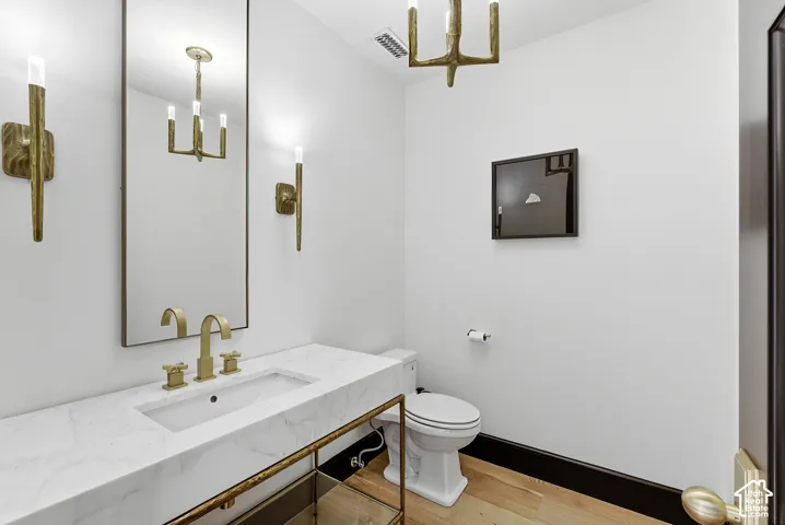 Integrated rectangular sink with brass faucet, white countertop, and brass sconces