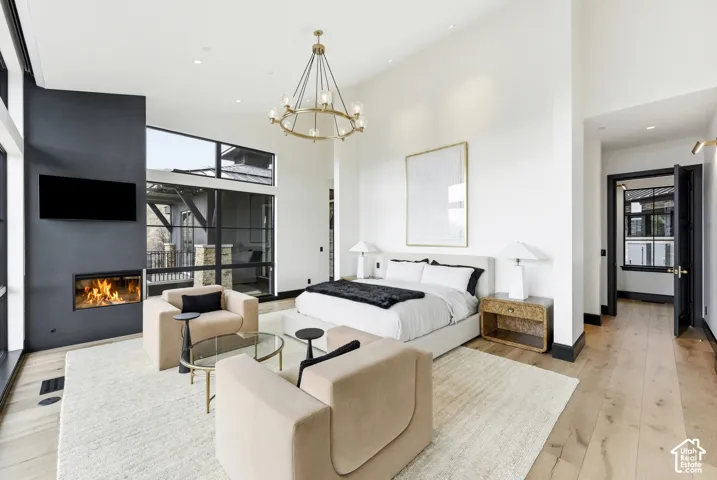 Expansive room featuring high ceilings, wood-finish flooring, and a built-in fireplace