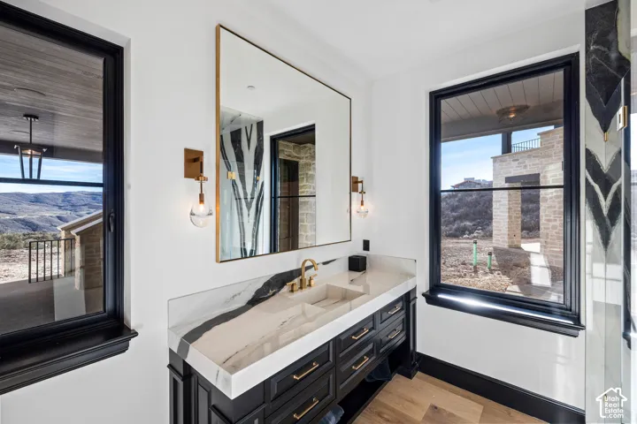Floating vanity with integrated sink, gold-finish fixtures, and a framed mirror