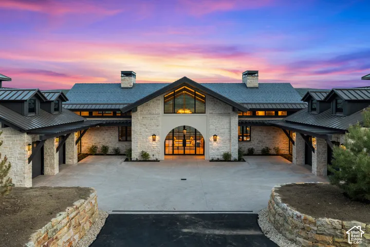 Stone facade exterior featuring an arched entryway and large windows