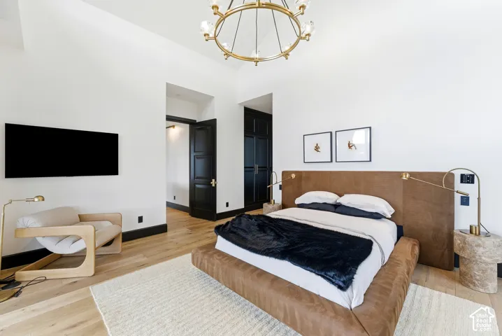 Vaulted white ceilings, light wood-finish flooring, and black paneled doors