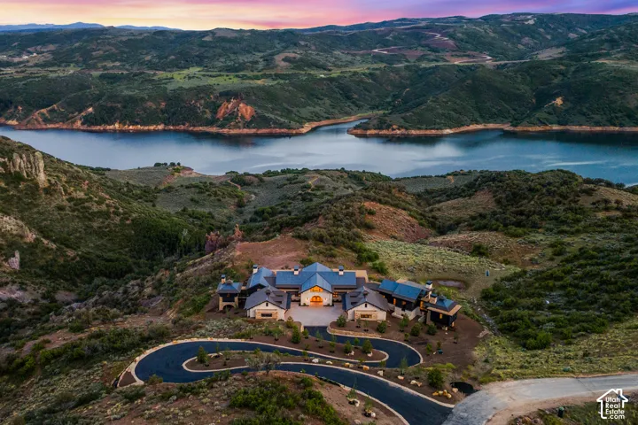 Extensive property featuring multiple structures, a winding paved driveway, and a natural landscape