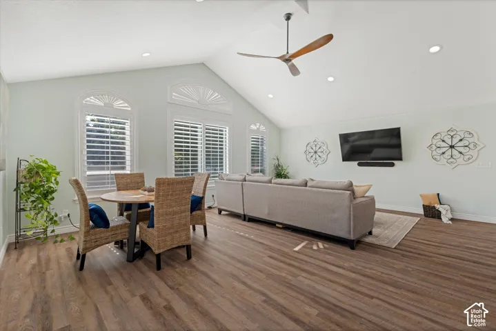 Vaulted ceiling with a contemporary ceiling fan, recessed lighting, wood-finish flooring, and arched windows with plantation shutters