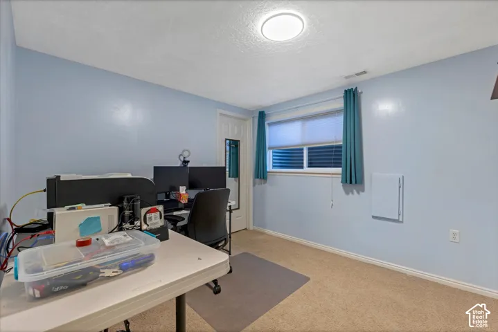Carpeted flooring, light blue wall paint, and a window with blinds