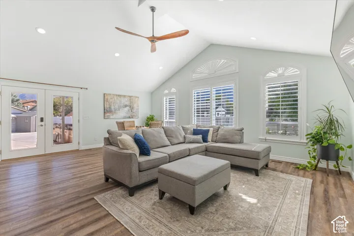 Vaulted ceiling with a wood-finish ceiling fan, recessed lighting, wood-finish flooring, and double French doors