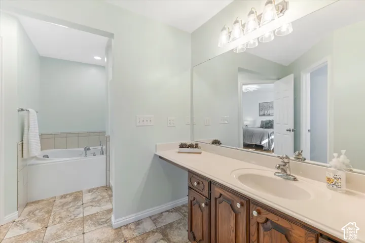 Vanity with an integrated sink and a large wall-mounted mirror