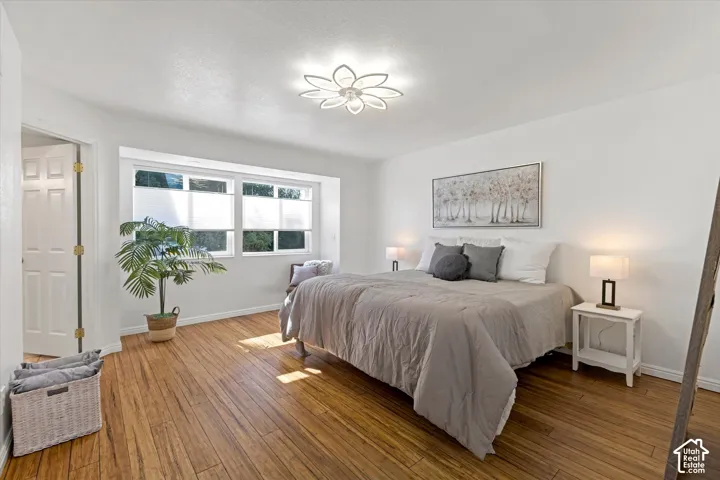 Hardwood flooring, abundant natural light, recessed window, white interior walls, and an overhead lighting fixture