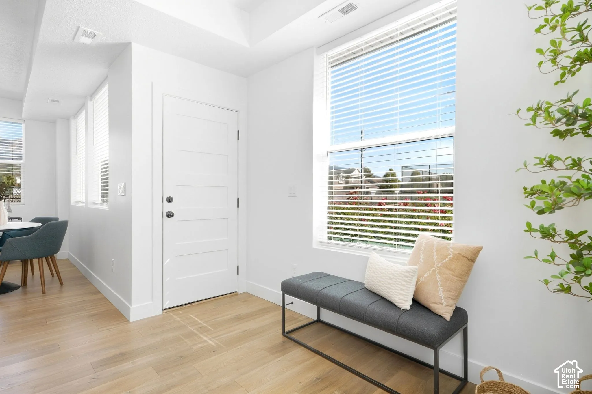 Light wood-finish flooring, white walls, and recessed lighting