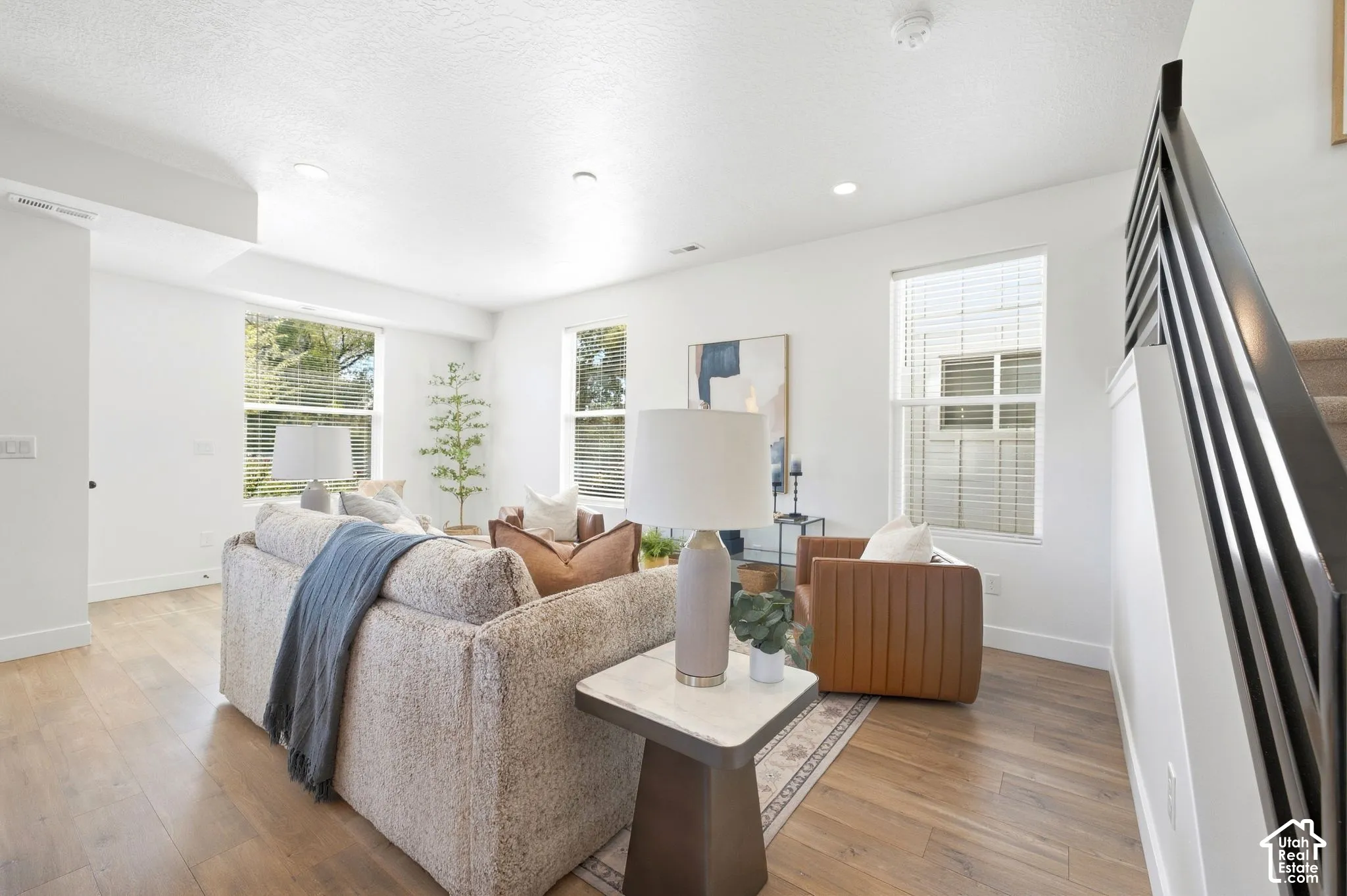 Wood-finish flooring throughout, complemented by a modern open-slat staircase railing