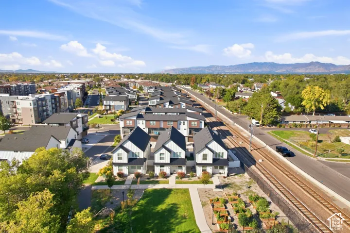 Modern residential development featuring multi-story residences, dark-pitched roofs, and white siding