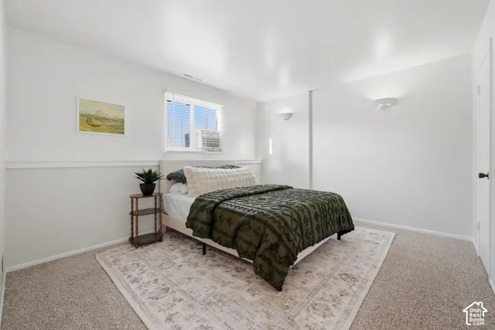 Carpeted flooring, white walls, built-in wall sconces, and a window with blinds