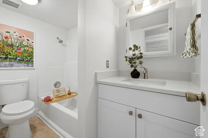 Bathroom featuring a white vanity with an integrated sink, polished chrome faucet, built-in medicine cabinet, and a shower-tub combination