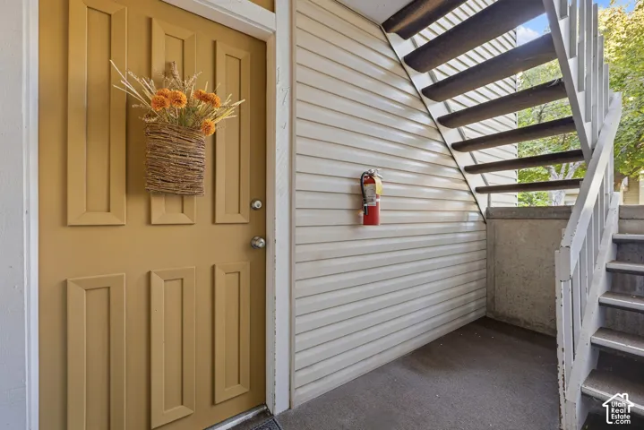 Exterior entry featuring a paneled door, horizontal siding, and an adjacent staircase
