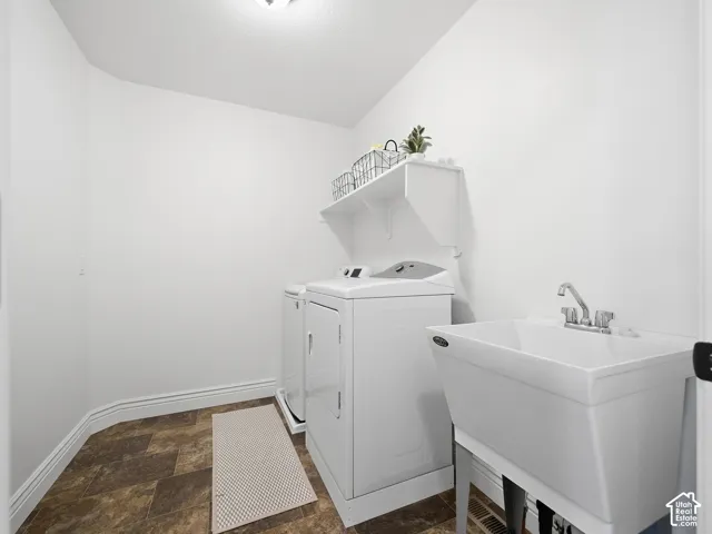 Utility room featuring a built-in shelf, white walls, and multi-toned flooring
