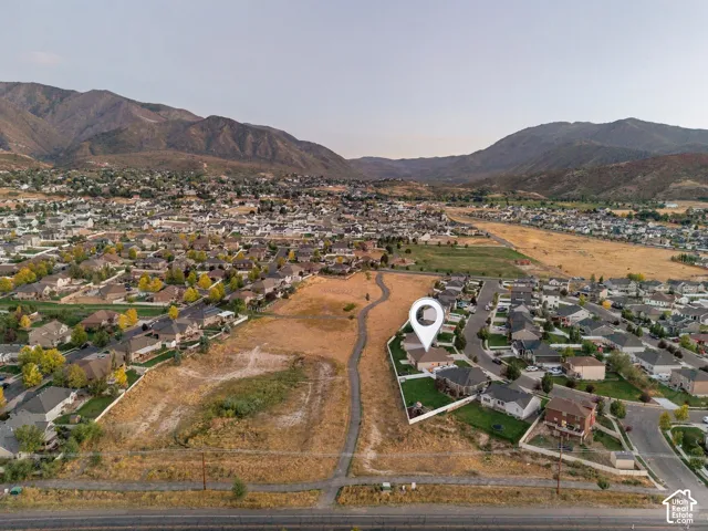 Expansive mountain backdrop with a residential community, featuring a suburban street grid and scattered green spaces