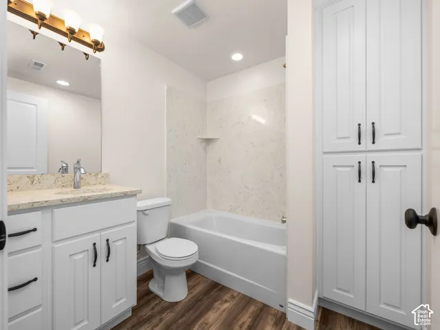 White vanity with a stone countertop and chrome faucet