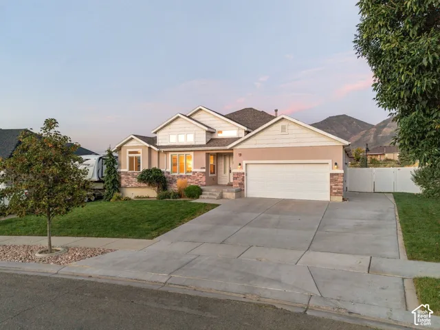 Exterior featuring a two-car garage, stone and stucco facade, and a concrete driveway