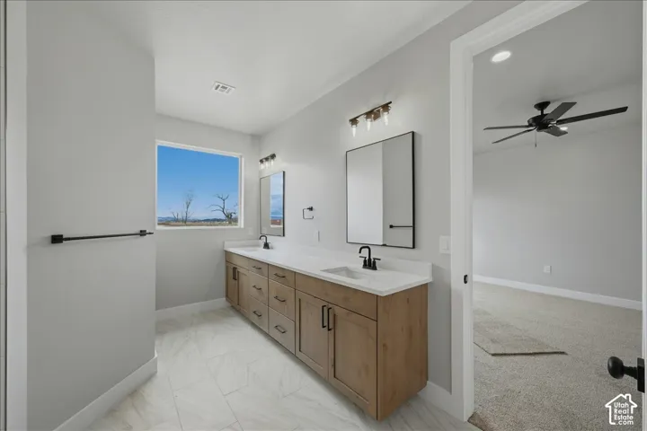 Dual vanity with wood-finish cabinetry, white countertops, and undermount sinks