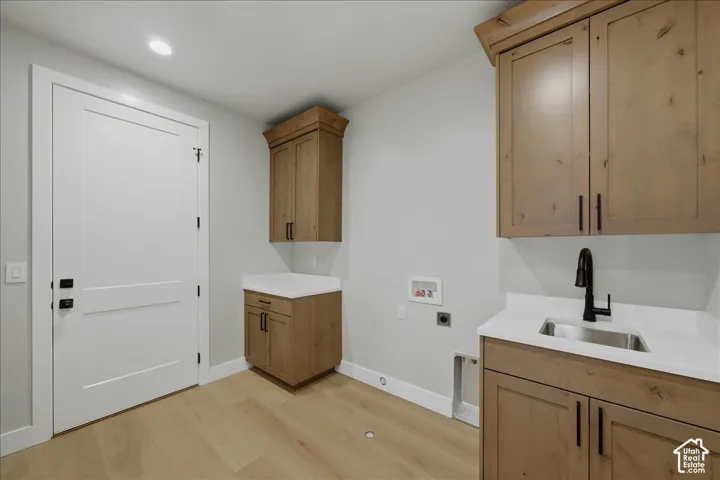 Wood-finish flooring, recessed lighting, and a white interior door with dark hardware