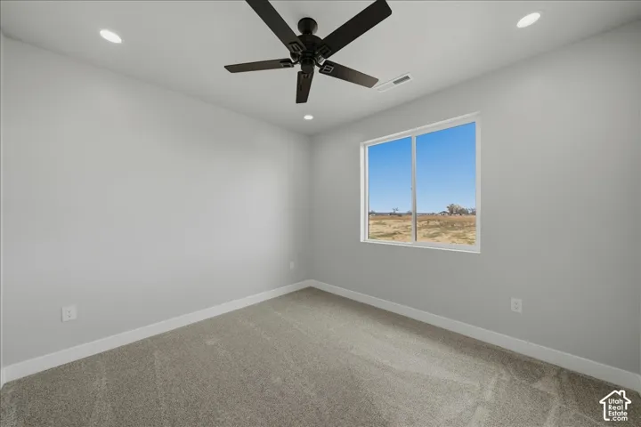 Recessed lighting, ceiling fan, carpeting, and a large window