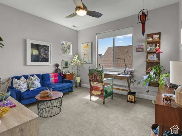 Recessed lighting, ceiling fan, large window, additional high window, and wood-finish desk
