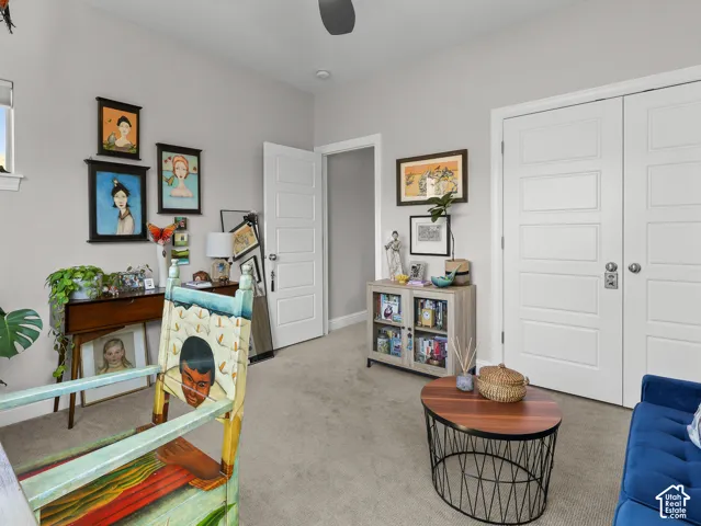 Neutral carpeting throughout, window with white trim, white paneled doors, recessed lighting, and a ceiling fan