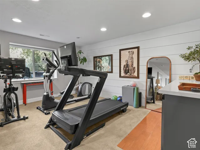 Recessed lighting, shiplap accent wall, carpeting, and a window with a garden outlook
