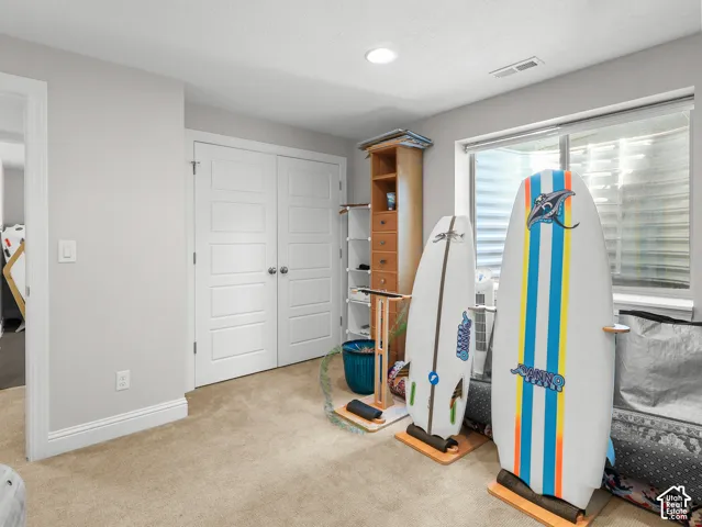 Recessed ceiling lighting, light neutral wall paint, carpeted flooring, white trim, and a window with blinds