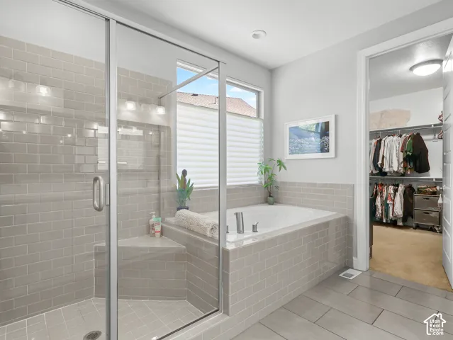 Glass-enclosed shower with subway tile surround and built-in bench